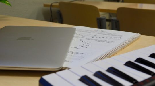 Muha-luokan opiskeluvälineitä: kannettava tietokone, koskemisto ja oppikirja